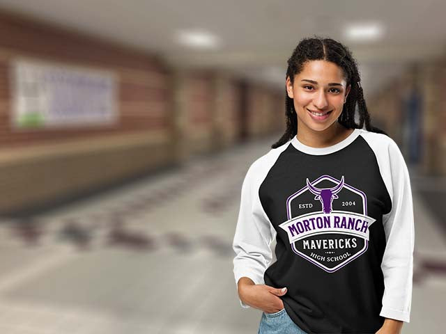 Person wearing a black and white long-sleeve shirt with 'Morton Ranch Mavericks' design in a school hallway.