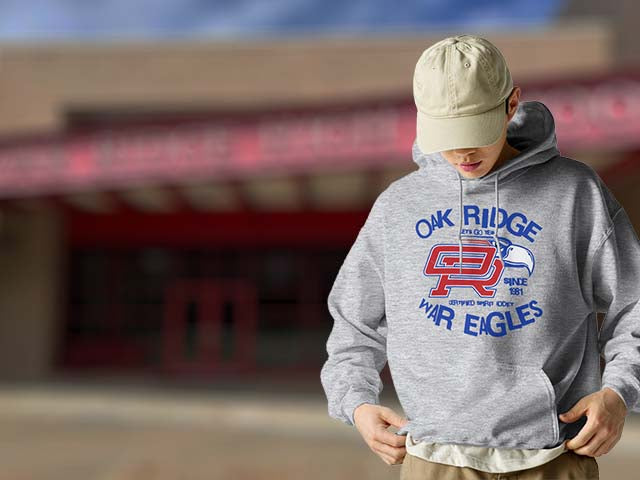 Person wearing a gray hoodie with 'Oak Ridge War Eagles' design outdoors.