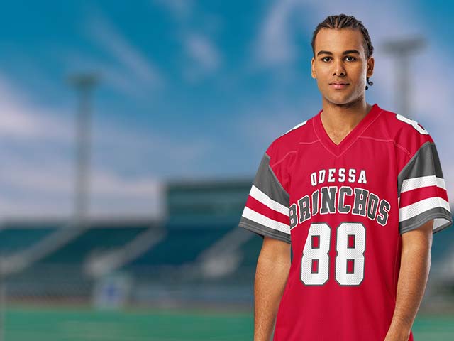 Person wearing a red 'Odessa Broncos' jersey with the number 88 on a sports field background.