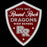 A shield-shaped school emblem reading 'Round Rock Dragons High School' with 'ESTD 1913' at the top, a large 'RR' monogram, and small star accents on a black background.