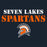 A dark navy graphic with the words 'SEVEN LAKES SPARTANS' in large white and orange distressed lettering above a Spartan helmet logo in orange, white, and dark navy. Seven Lakes High School Spartans Women's Navy Blue SoftStyle T-shirt 017