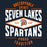 A graphic design for a t-shirt featuring the text 'UNSTOPPABLE SPIRIT SEVEN LAKES SPARTANS PROUD TRADITION' in distressed white and orange lettering, with a central diamond logo containing a Spartan helmet icon. 