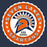 A circular school logo sticker or decal reading 'SEVEN LAKES SPARTANS HIGH SCHOOL' with an orange ring, white scalloped border, navy and orange Spartan helmet, and white stars on a dark blue background. Seven Lakes High School Spartans Unisex 3/4 sleeve Raglan T-shirt 216