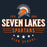 A dark navy graphic design featuring an orange and white Spartan helmet logo above the text 'SEVEN LAKES SPARTANS' and 'HIGH SCHOOL,' with 'ESTD 2005' and white stars. Seven Lakes High School Spartans Women's Navy Blue SoftStyle T-shirt 217