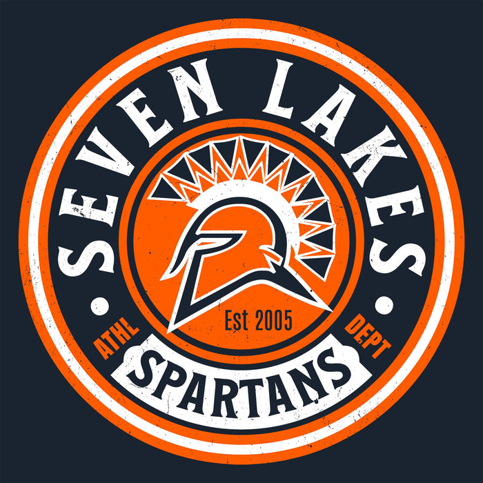 A circular sports logo for 'Seven Lakes Spartans' featuring an orange and navy blue Spartan helmet emblem with a stylized sunburst, set against a dark navy background. Seven Lakes High School Spartans Women's Navy Blue SoftStyle T-shirt 220