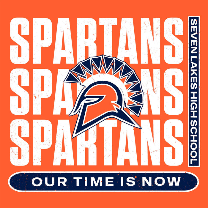 A square orange graphic with repeated distressed white 'SPARTANS' text, a central Spartan helmet logo in navy and orange, a vertical black banner reading 'SEVEN LAKES HIGH SCHOOL' on the right, and a navy rounded bar at the bottom reading 'OUR TIME IS NOW'. Seven Lakes High School Spartans Orange Classic Unisex T-shirt 235