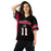 Woman wearing a black Spartans sports jersey with red and white accents on a white background