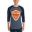 A man wearing a 3/4 sleeve raglan t-shirt with a heather slate blue body and navy blue sleeves. The shirt features a large orange, white, and navy shield graphic on the chest that reads 'Seven Lakes Spartans High School' with a Spartan helmet logo. Seven Lakes High School Spartans Unisex 3/4 sleeve Raglan T-shirt 225