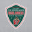 A shield-shaped graphic print on a light gray heathered fabric background. The graphic features a dark green background with a white border, red accents, and the text 'THE WOODLANDS HIGHLANDERS HIGH SCHOOL' along with a mascot holding a sword and a large red 'W'. The Woodlands High School Highlanders Grey Classic Unisex Sweatshirt 218