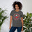 Woman wearing North Shore High School Mustangs Dark Grey Premium Unisex T-shirt 214