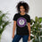 Woman wearing a Morton Ranch High School Mavericks Premium Black Unisex T-shirt 204