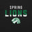 A close-up of a black garment featuring a 'SPRING LIONS' graphic print in white and green, with a stylized lion head logo below. Spring High School Lions Black Premium Unisex T-shirt 024