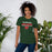 Woman wearing The Woodlands High School Highlanders Forest Green Premium Unisex T-shirt 024